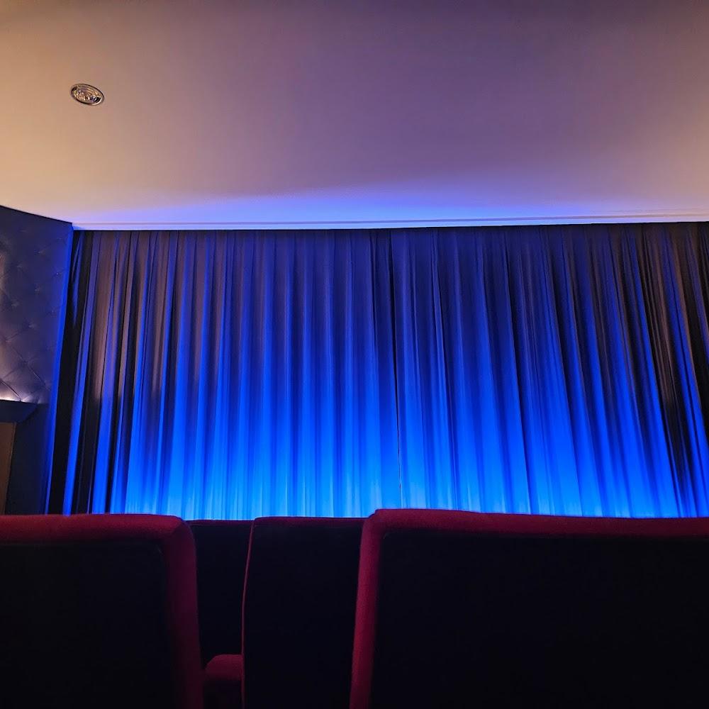 Blue curtains and burgundy seats in a theater.